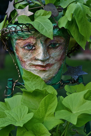 Garden planter with woman's face in garden